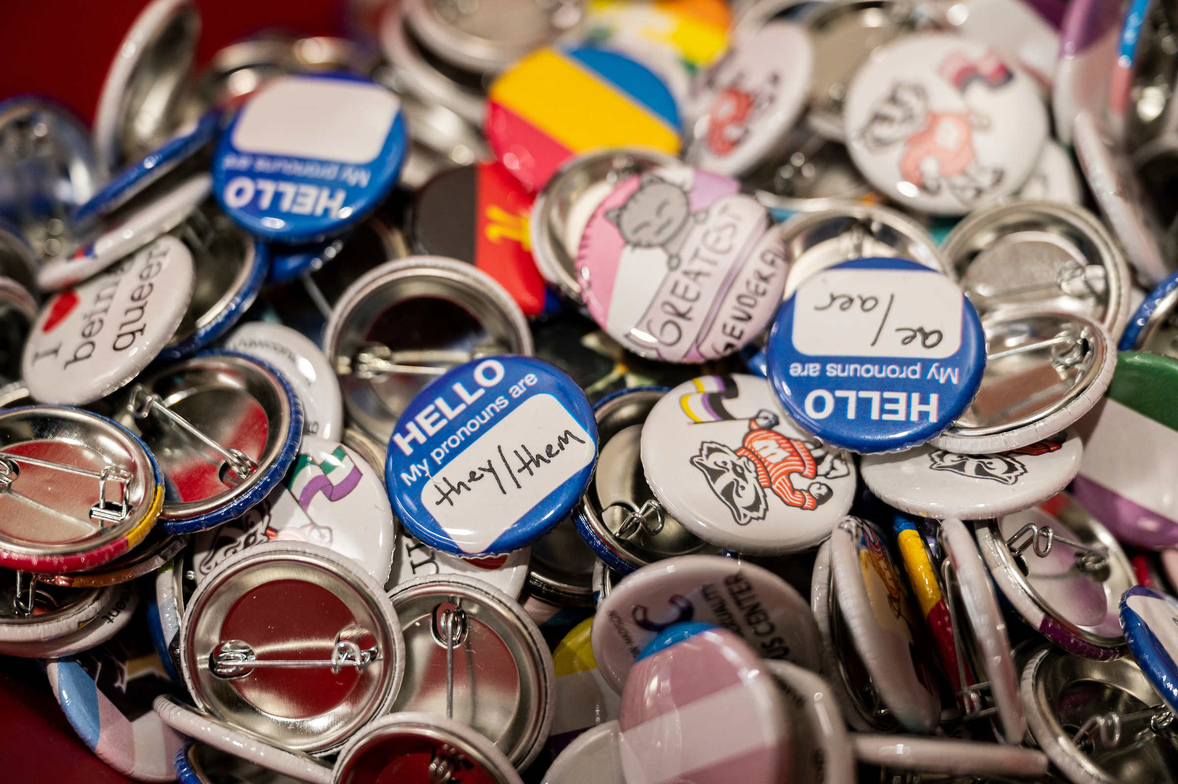 Buttons with pronouns and gender and sexuality supportive statements.