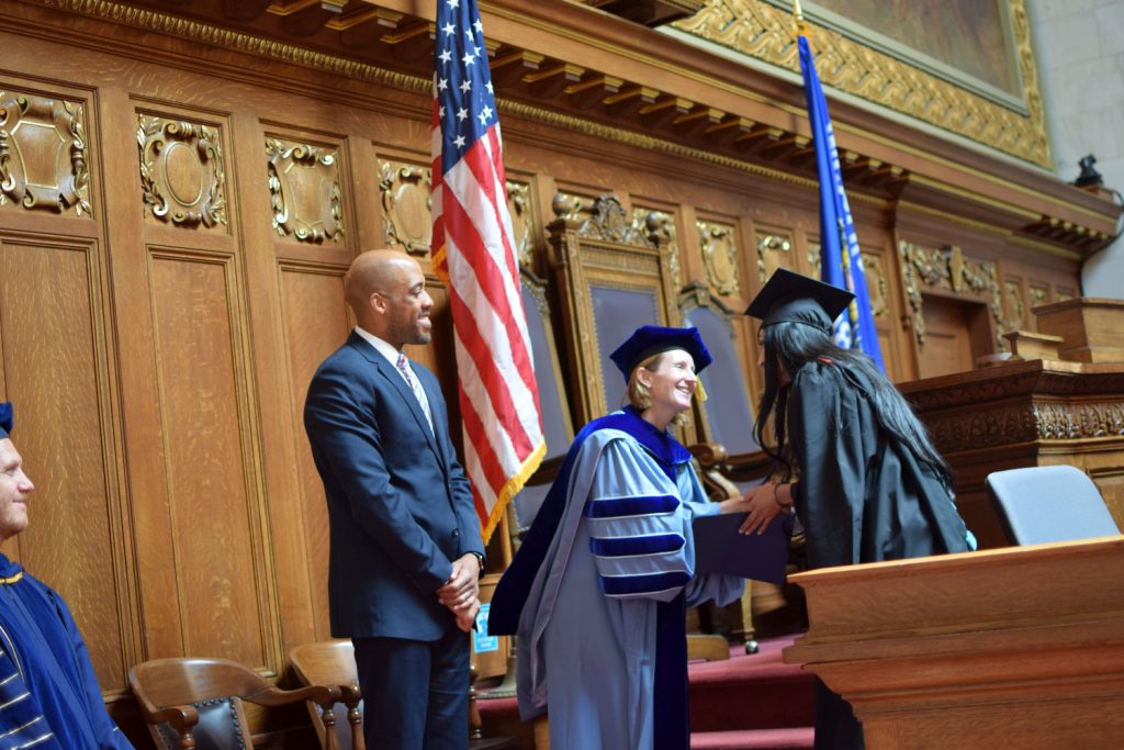 Director Susan Yackee shakes a student's hand
