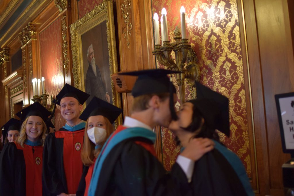 Two students kiss while in line before the graduation ceremony