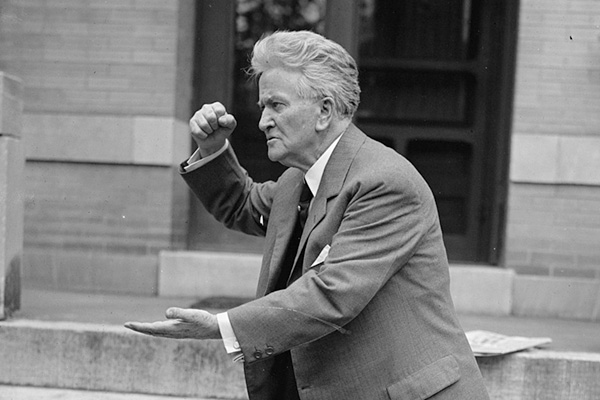 Robert La Follette faces sideways with his fist in the air