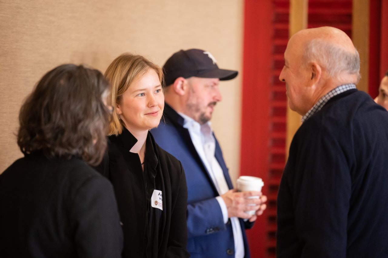 People stand and talk during a lunch event.
