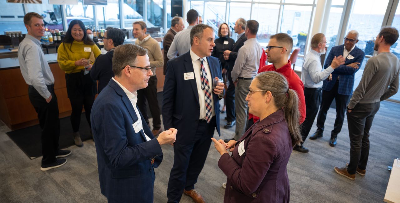People stand and talk during a reception.