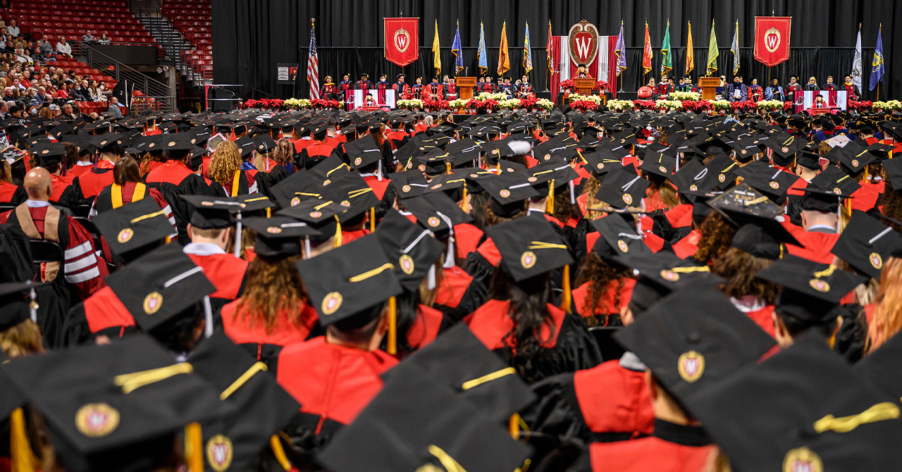 Students wearing caps and gowns listen to Chancellor Mnookin.