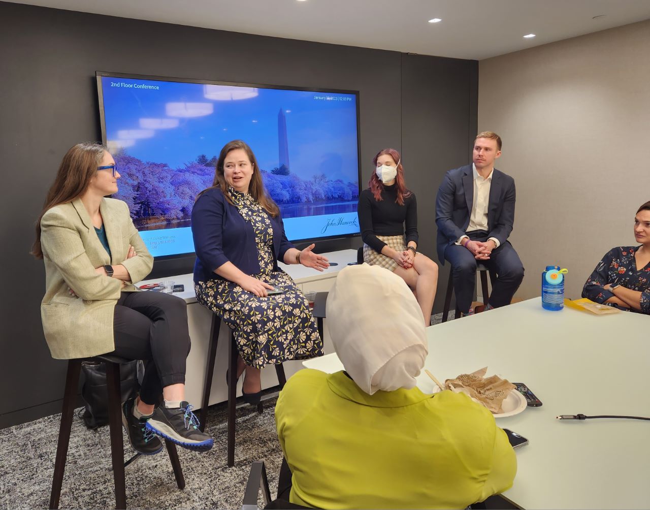 Four alumni address current students in a conference room.
