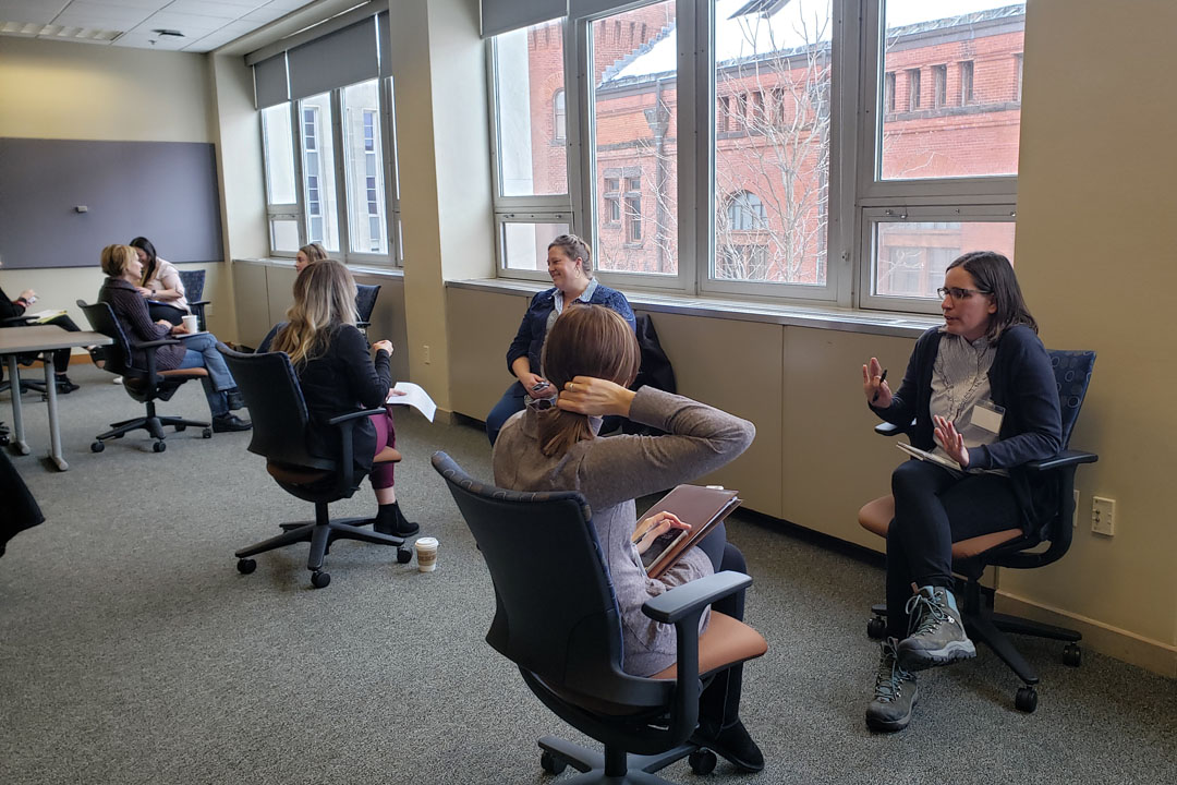Seminar attendees sit facing each other for an activity.