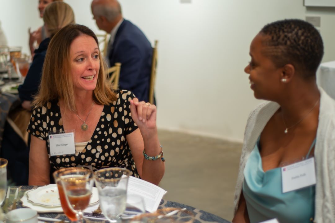 Lisa Ellinger chats with another event participant seated next to her.