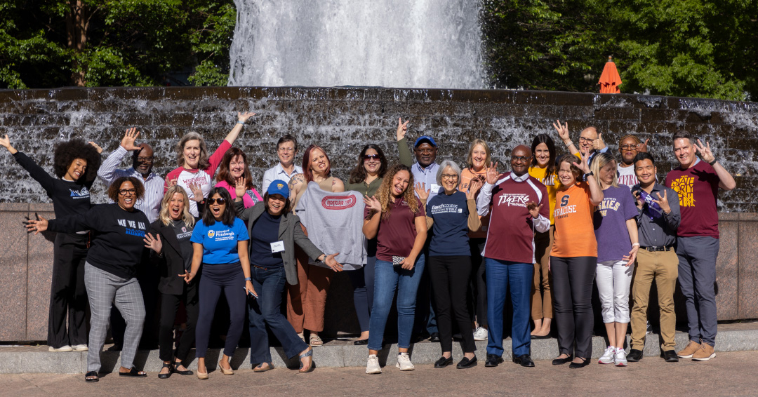 Group photo of staff standing in front of a fountain.