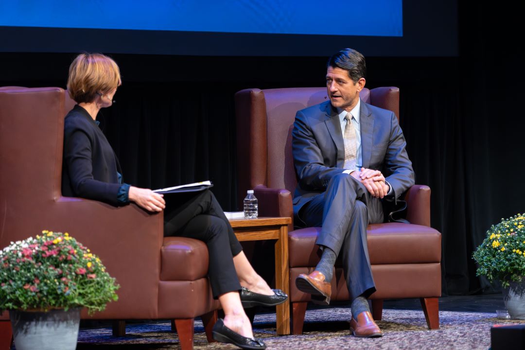 Paul Ryan and Susan Yackee sit in chairs on a stage