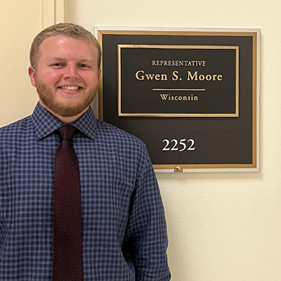 Matt Masonius stands next to a sign for US Representative Gwen Moore's office