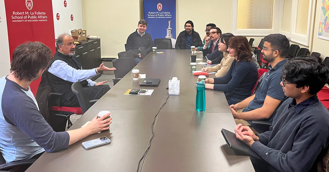 Students sit at a table with World Bank Chief Economist Indermit Gill.
