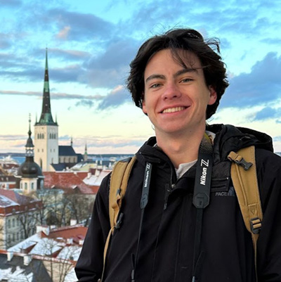Nick Charlton stands on a balcony overlooking a medieval town in the winter.