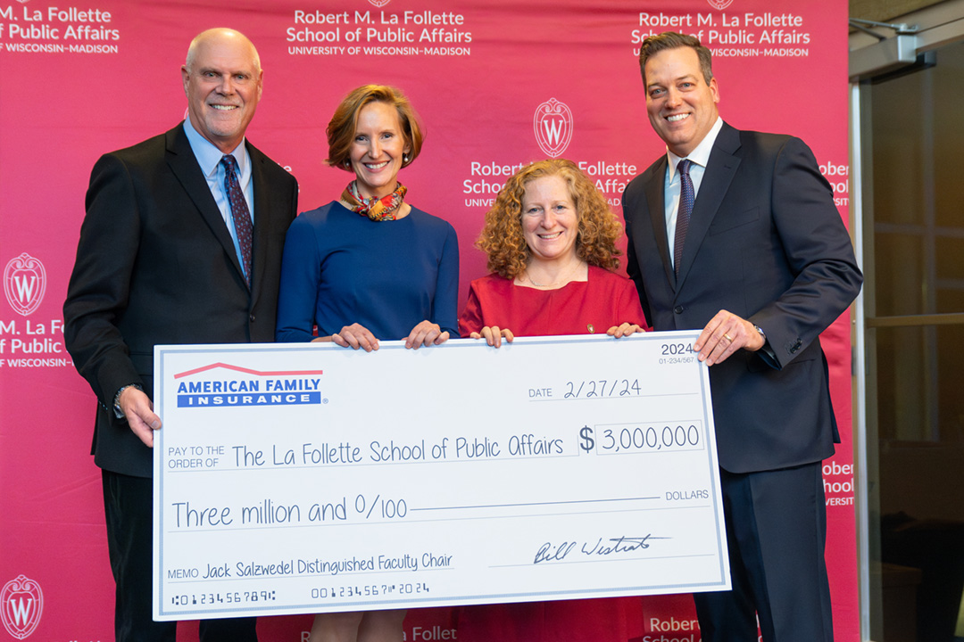 Jack Salzwedel, Susan Yackee, Jennifer Mnookin, and Bill Westrate hold a giant check.