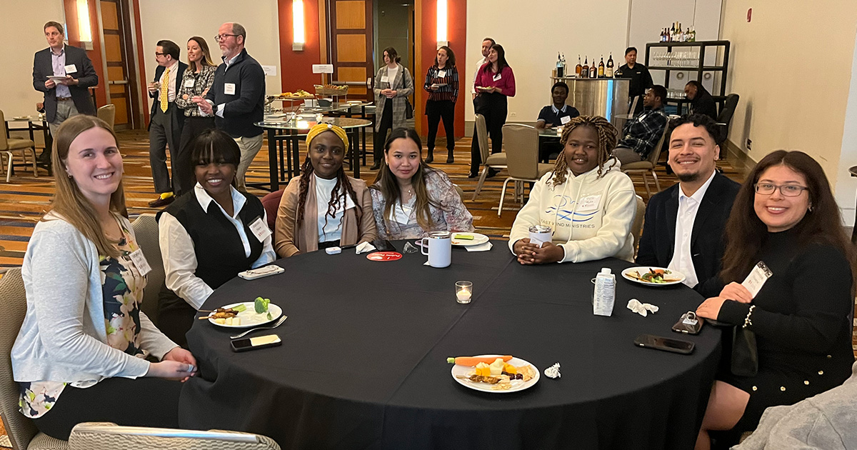 Students sit together to eat during a reception