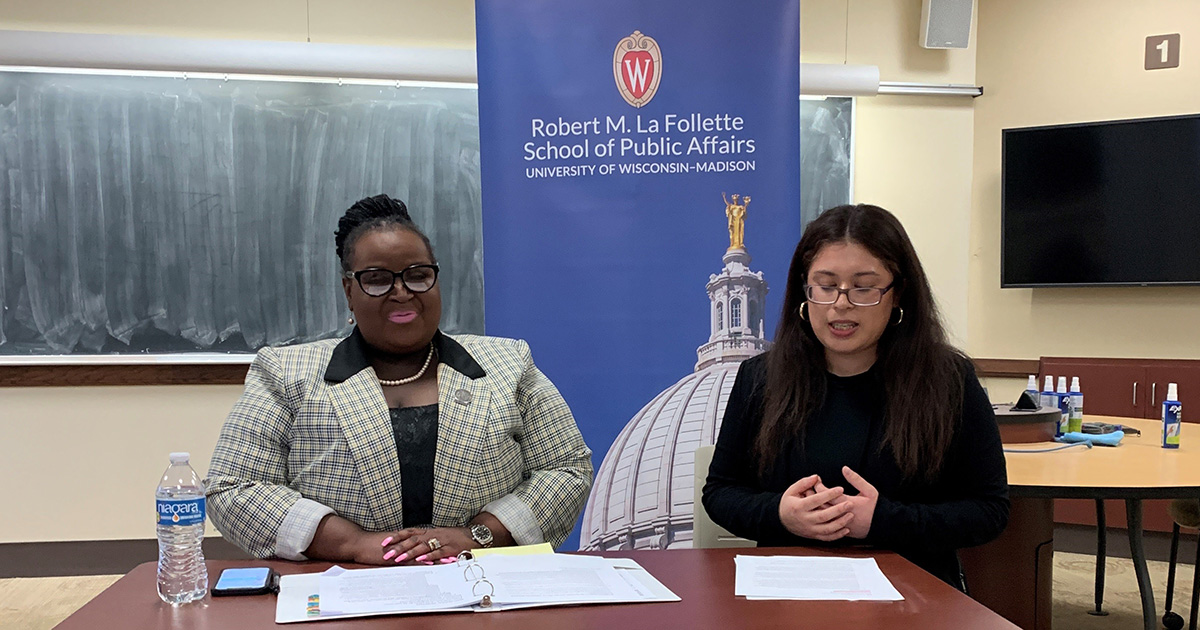 Representative Shelia Stubbs and Dominique Villaseñor sit in front of a banner with the La Follette School logo.