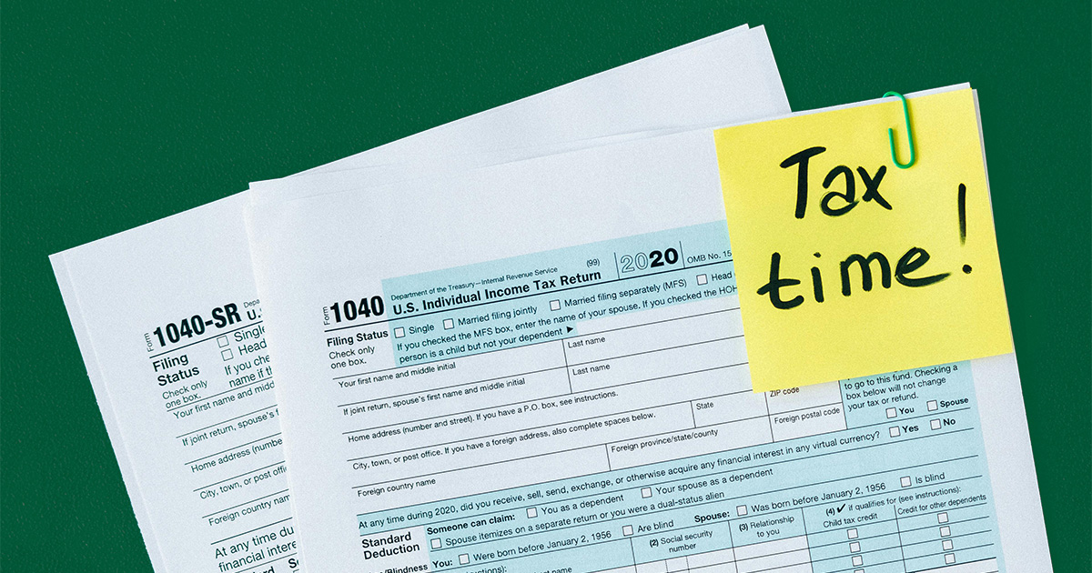 Tax documents and a post-it note saying "tax time!"