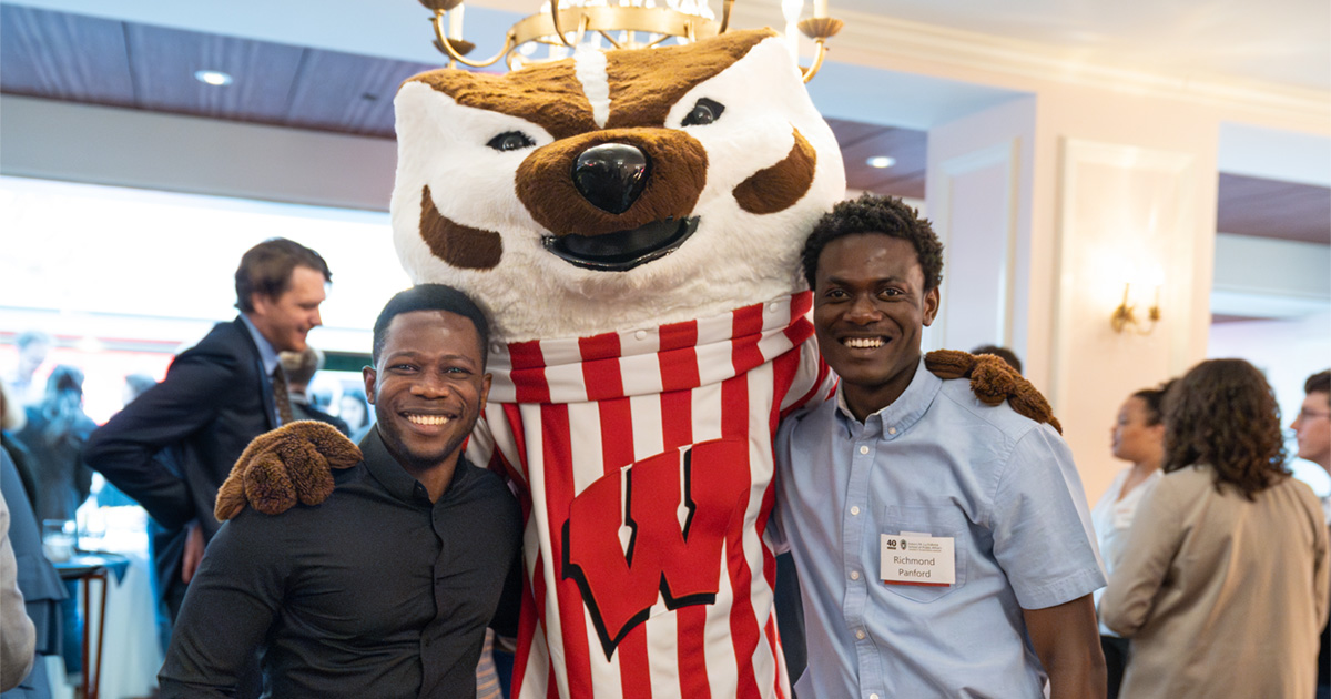 Francis Amedoadzi and Richmond Panford pose for a photo with the University of Wisconsin–Madison mascot Bucky Badger