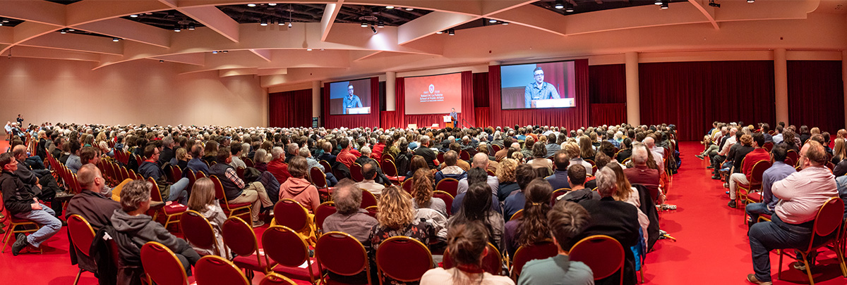 A large audience in the Monona Terrace listens to Ezra Klein's presentation