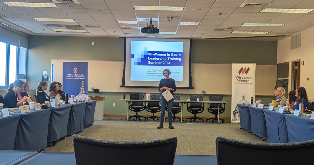 Susan Yackee stands to present to attendees during a seminar.