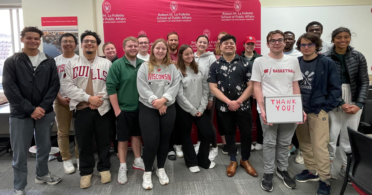 Students stand for a group photo while holding a "thank you" sign.