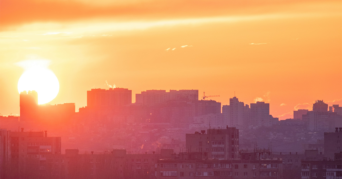 The sun sets over a city