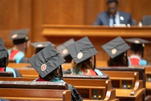 La Follette School master's degree graduates wearing caps and gowns sit during the 2024 graduation ceremony