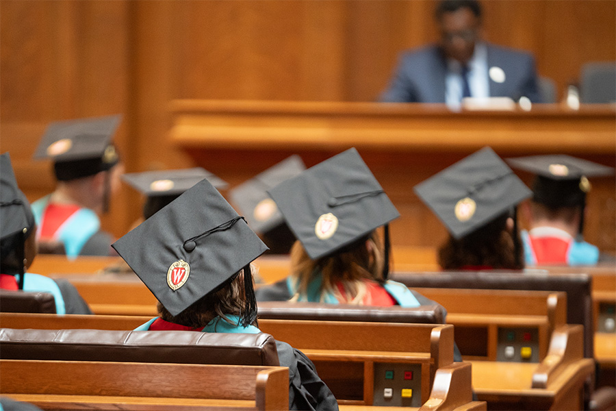 La Follette School master's degree graduates wearing caps and gowns sit during the 2024 graduation ceremony
