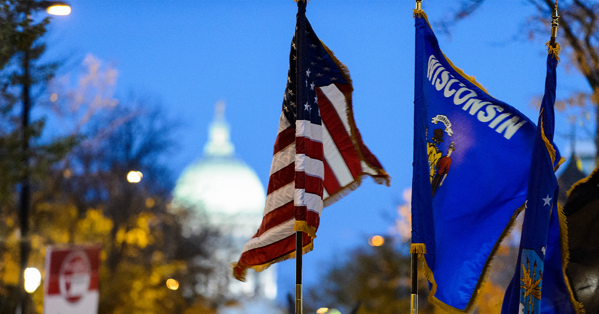 The U.S. and Wisconsin State flag fly on Madison's State Street with the Capitol in the background