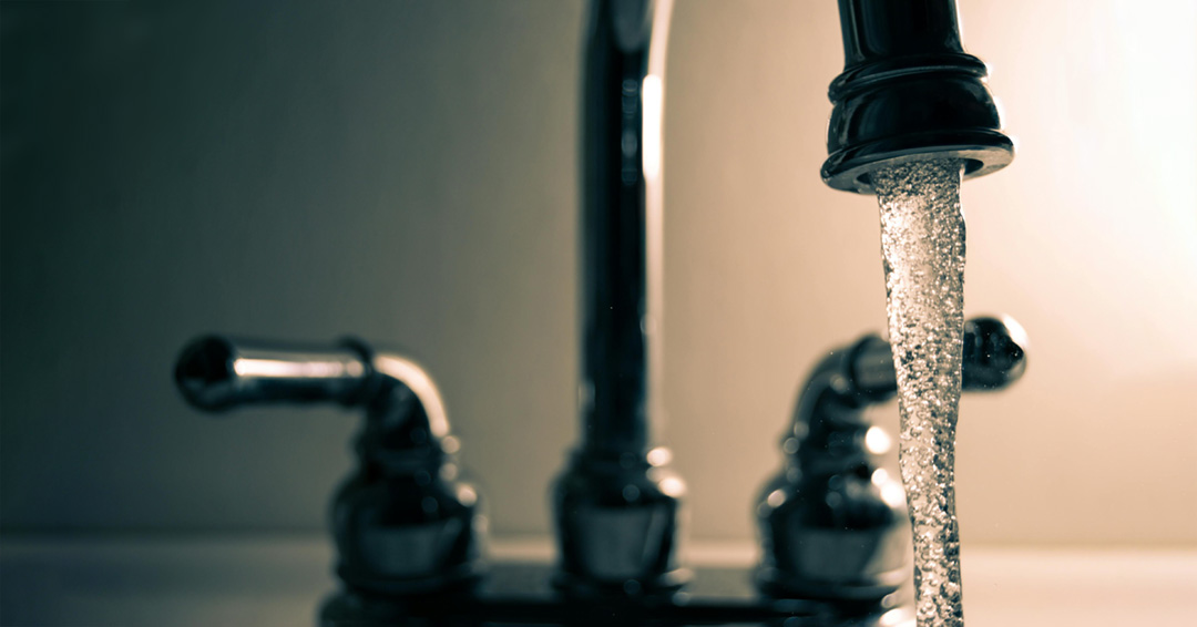 Faucet with water flowing from the nozzle.