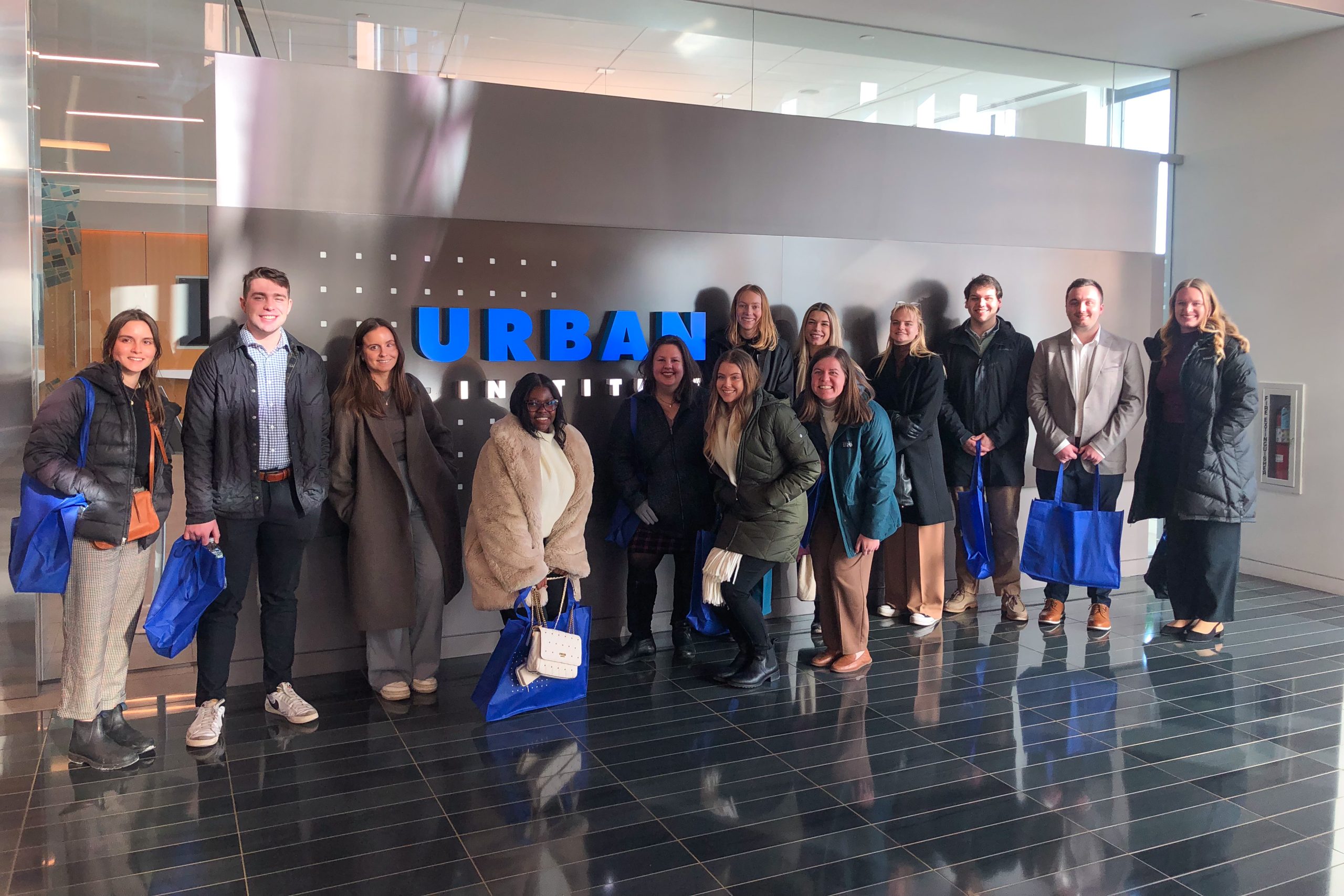 Students pose in front of a sign that reads "Urban Institute."