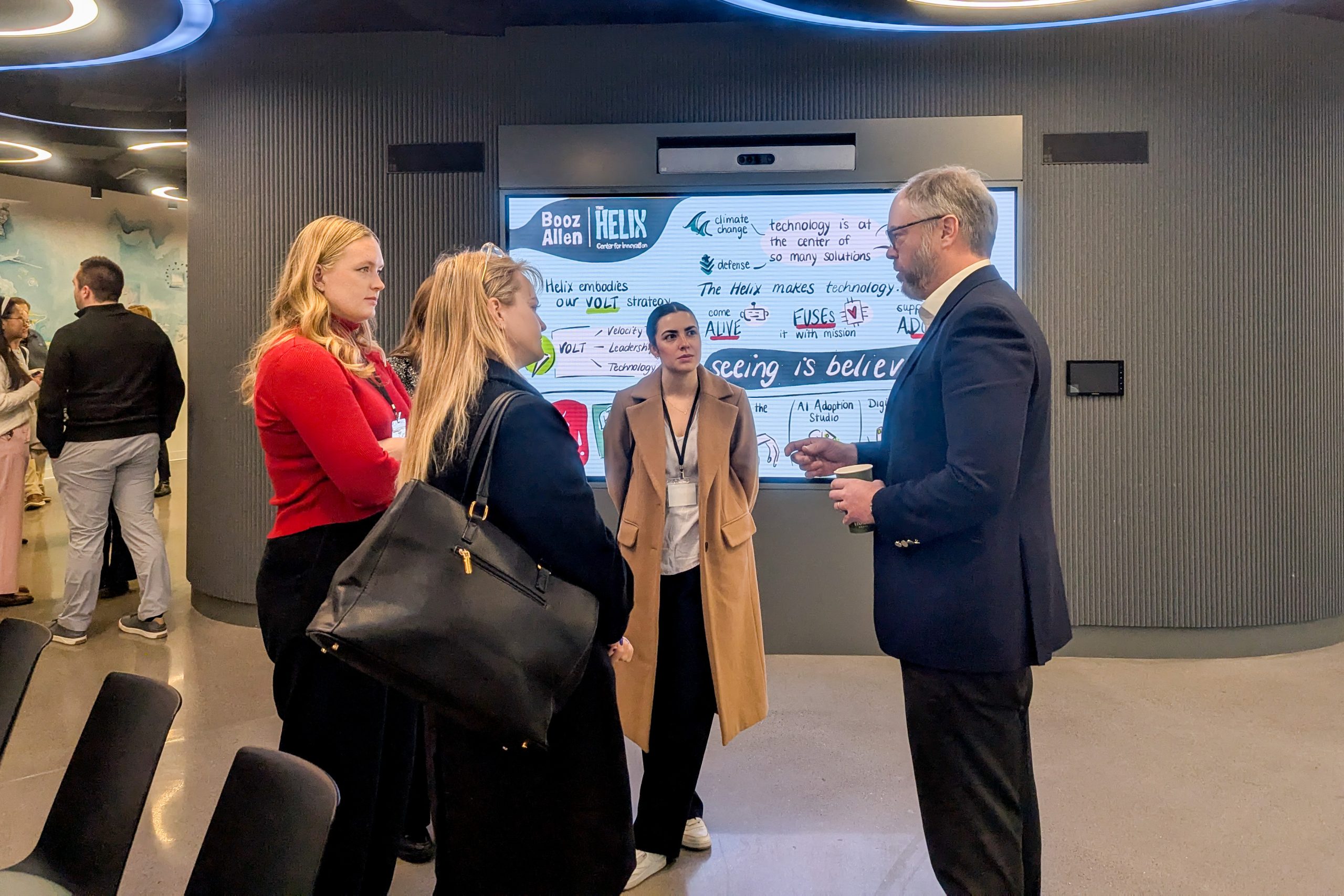 People mingle in the lobby of Booz Allen.