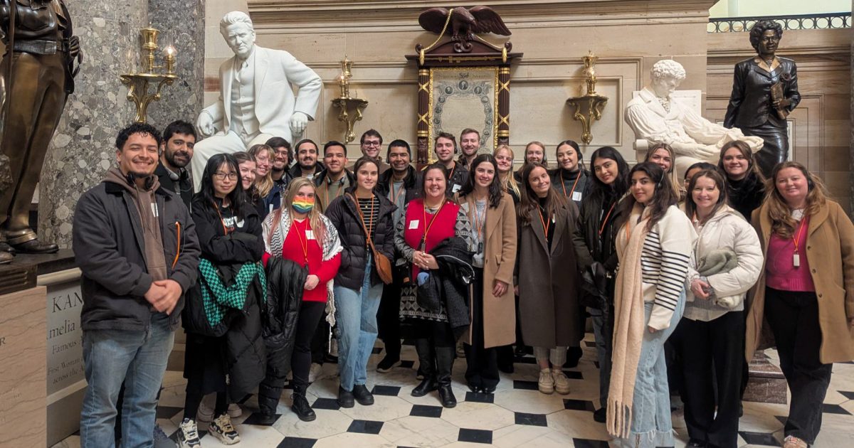 La Follette students pose in front of statues, including a Bob La Follette statue, as part of a Capitol tour.