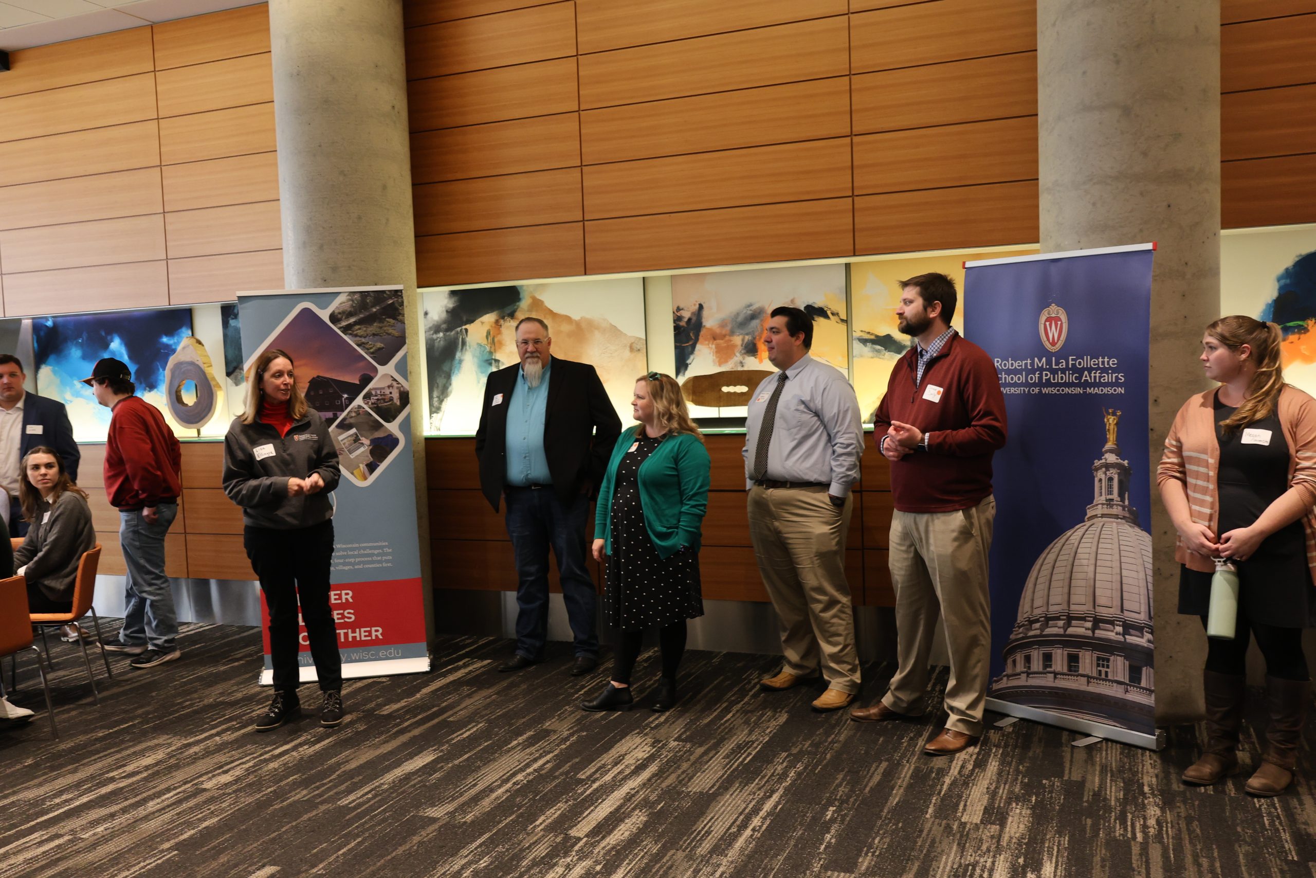 Four panelists stand at the front of the room presenting to students. 