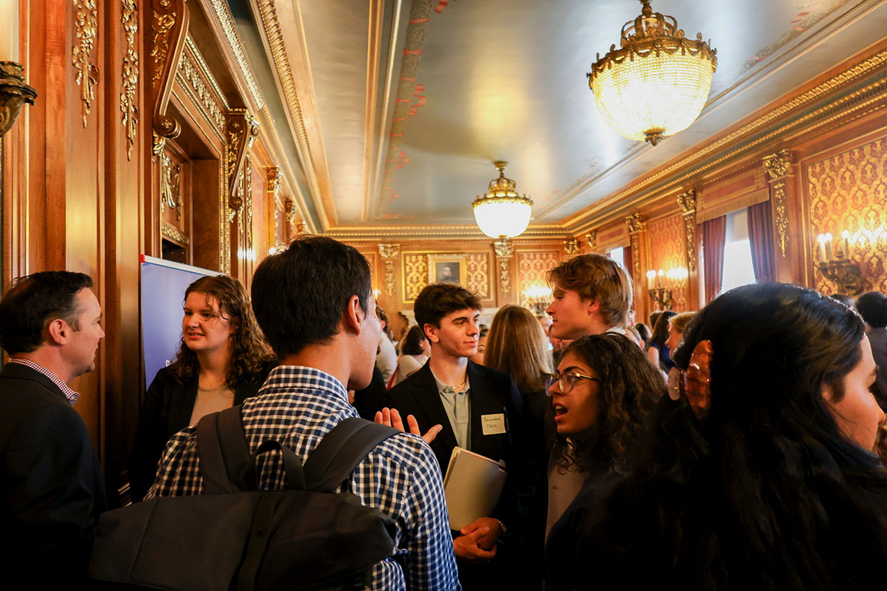 Multiple students and alumni talking at the event in the capitol.