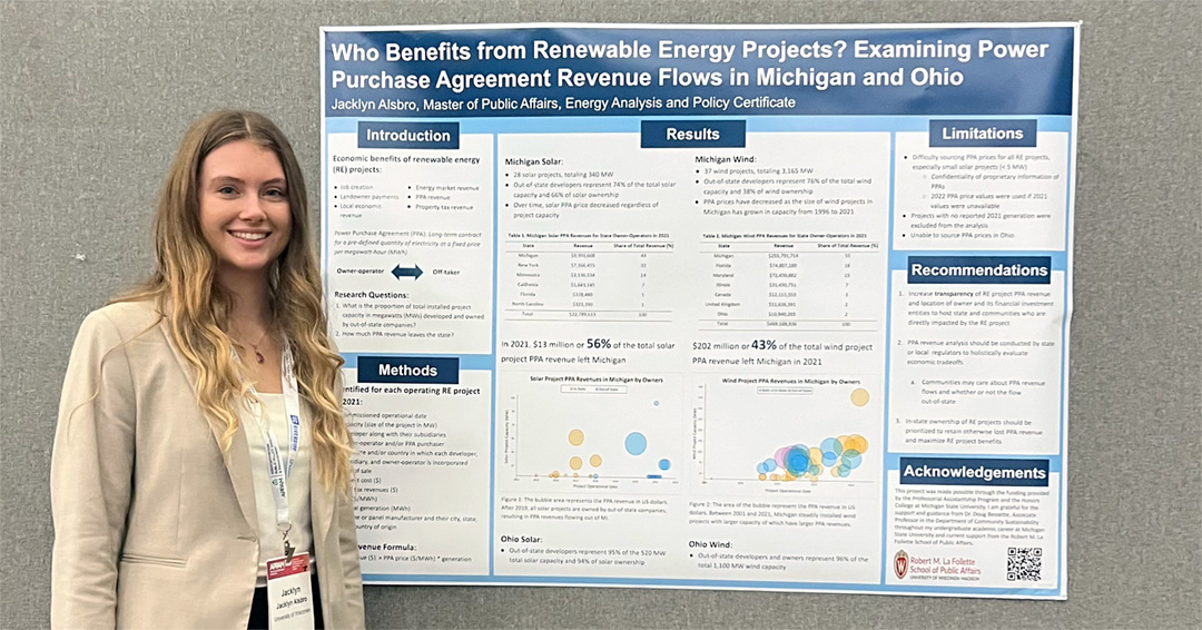 Jacklyn Alsbro stands next to her poster at the conference.